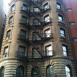Brick apartment building with fire escapes in New York